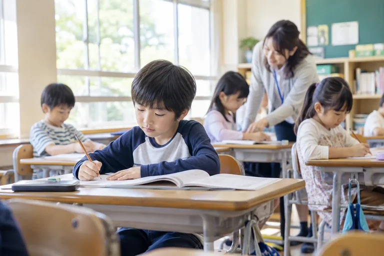 小学校の教室で学ぶ子どもたちと、そばで支える先生